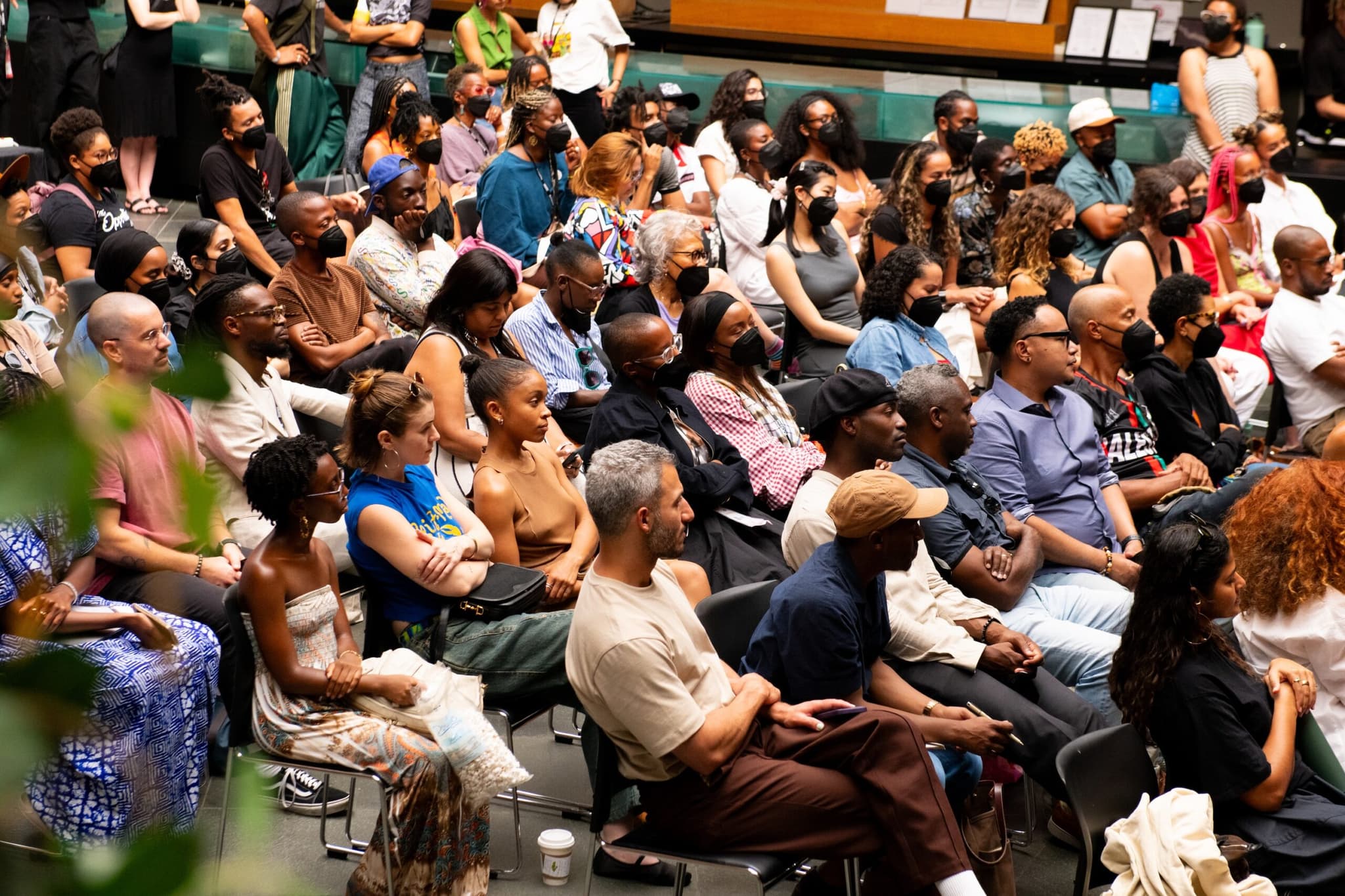 A photo of a seated audience intently watching or listening to something out-of-frame.