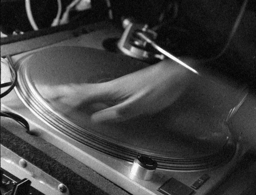A blurry hand on a turn table, photo in black and white