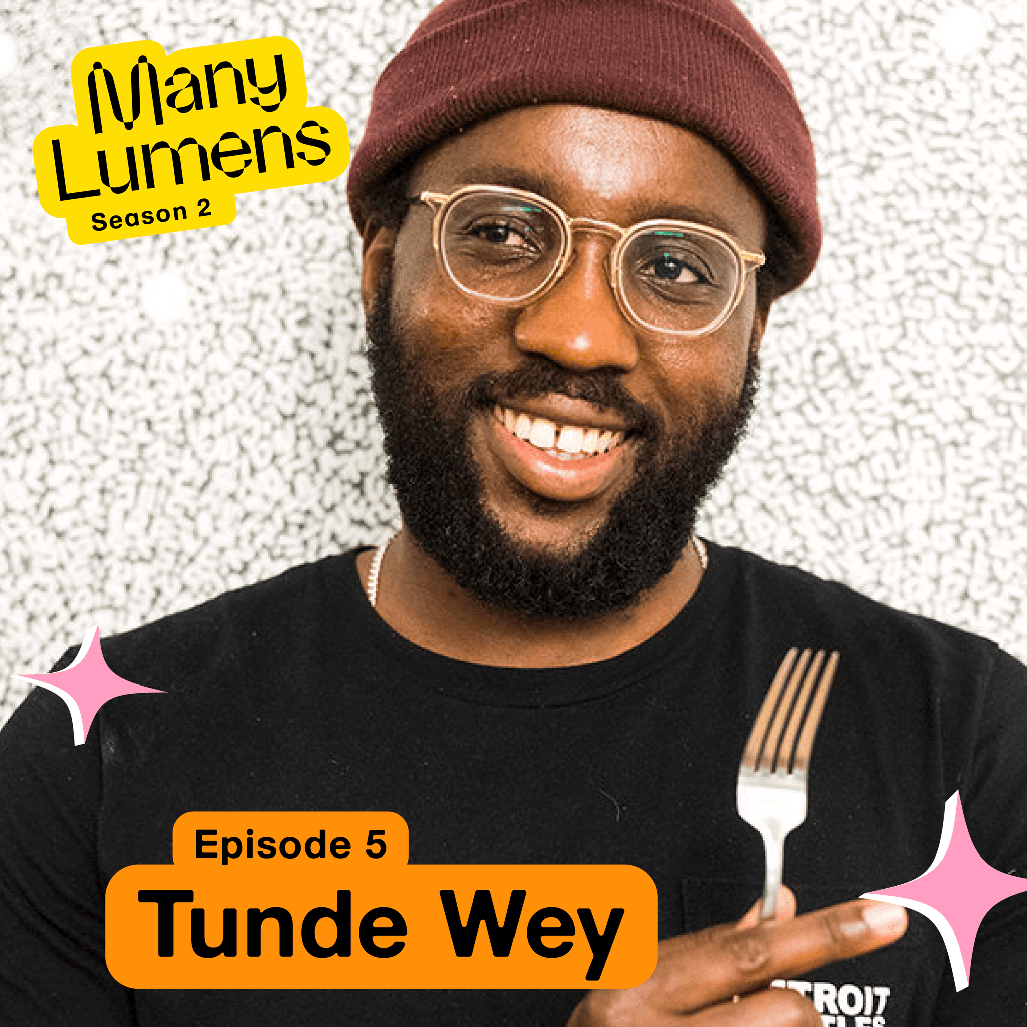 A headshot of Tunde Wey, he is wearing a burgundy beanie, a black shirt and has on clear glasses. He is holding up a fork, smiling, and looking slightly towards the left. The Many Lumens logo is the top left corner of the image and there are pink star graphics placed on it.