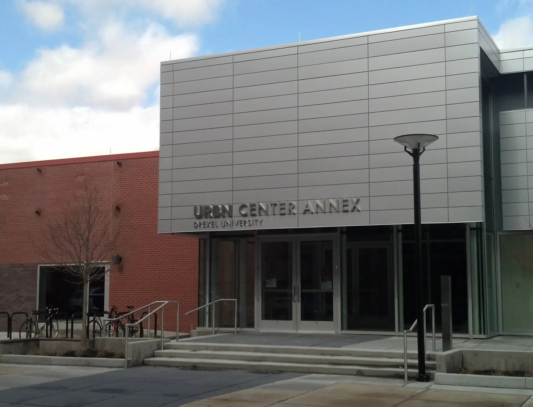 The front of an office building with "URBN Center Annex" written in silver lettering on top of a silver background.