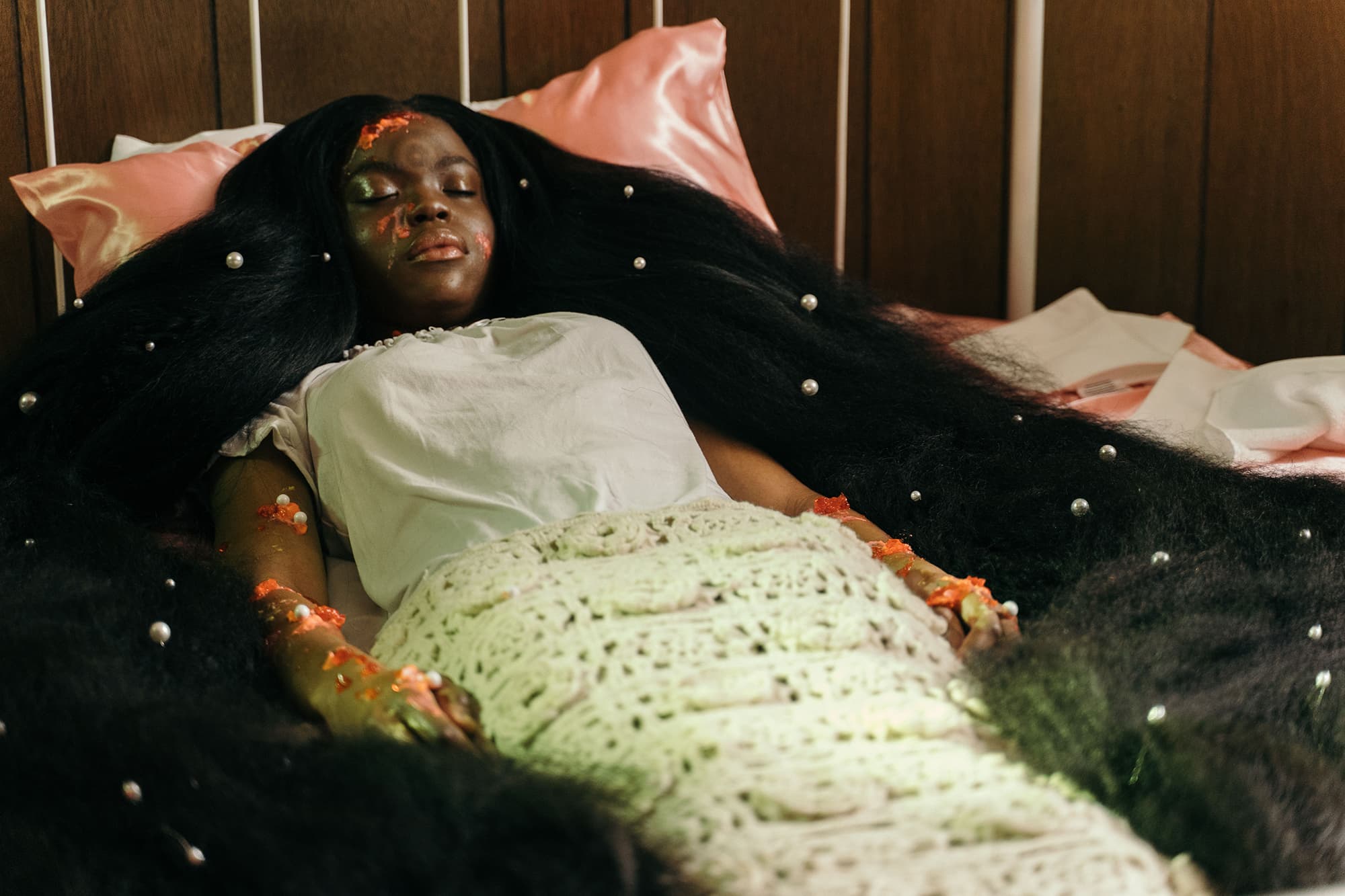 A still from Ourika! shows a young Black girl laying in a bed. Her hair is long and flowing across the mattress.
