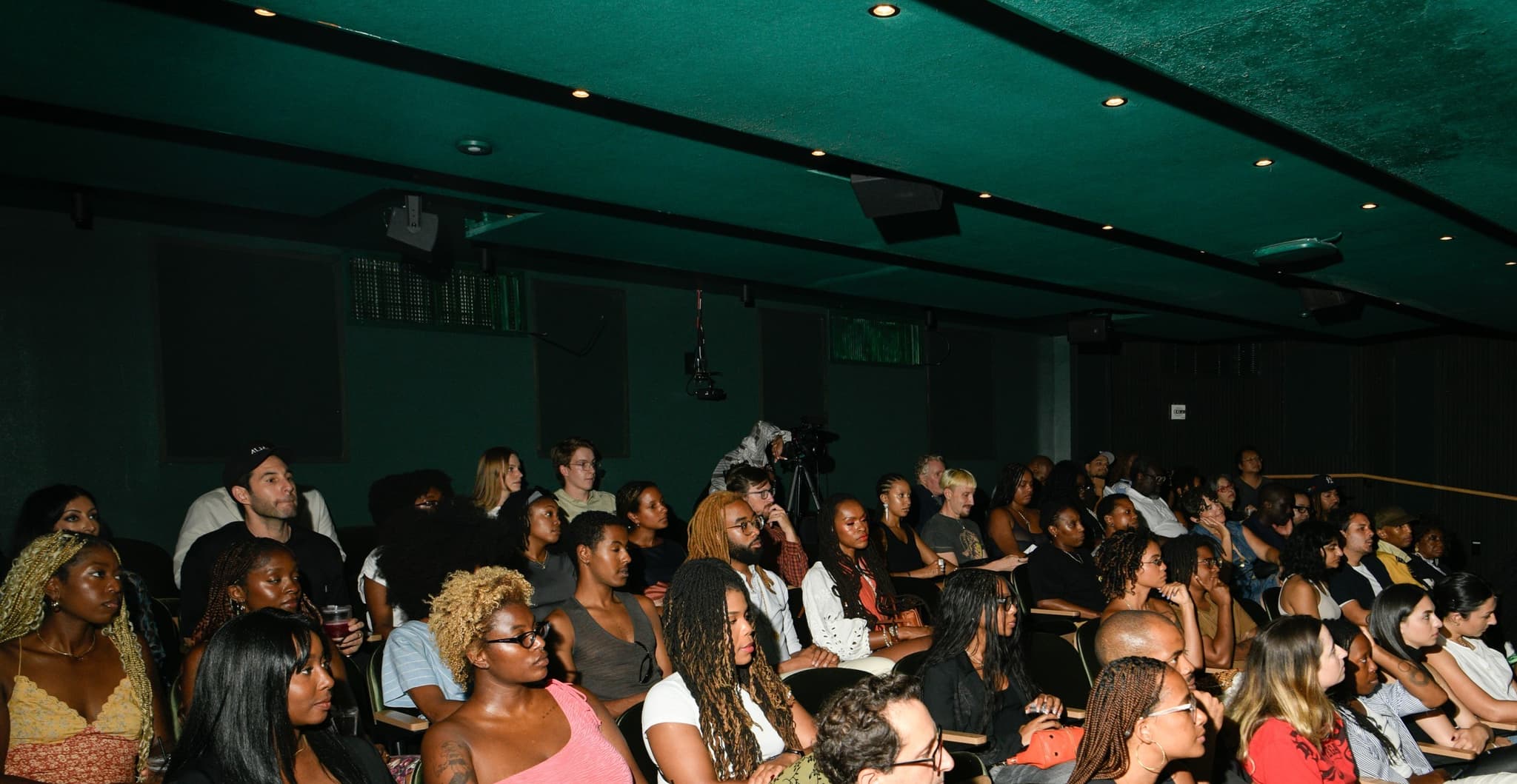 A photo of a theater filled with beautiful Black and Brown people.