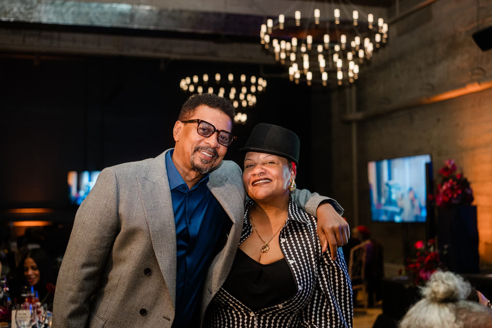 A photo of Robert Townsend and Radha Blank at the the 2025 Luminary Gala. They are standing arm-in-arm and are smiling.